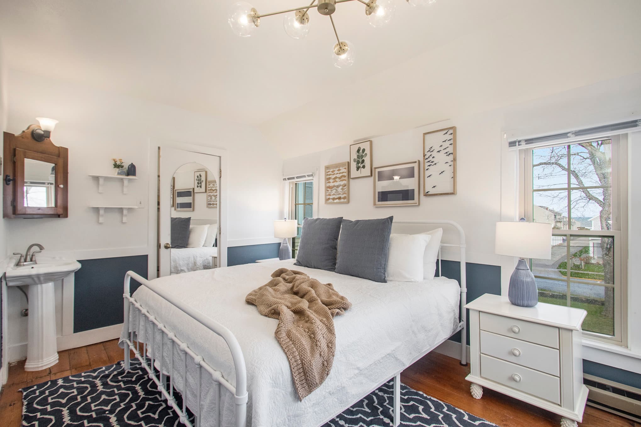 king bed, blue rug, sink and bathroom