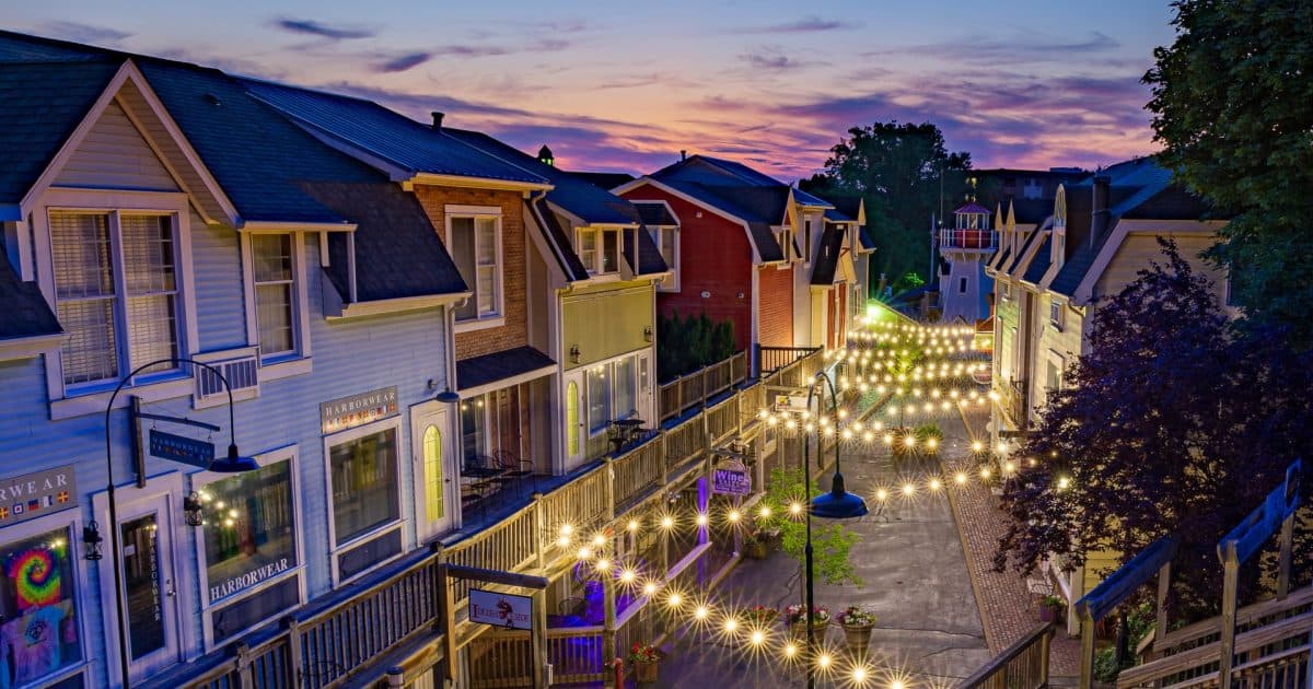 A charming street lined with colorful houses and twinkling string lights at sunset. A charming street lined with colorful houses and twinkling string lights at sunset.