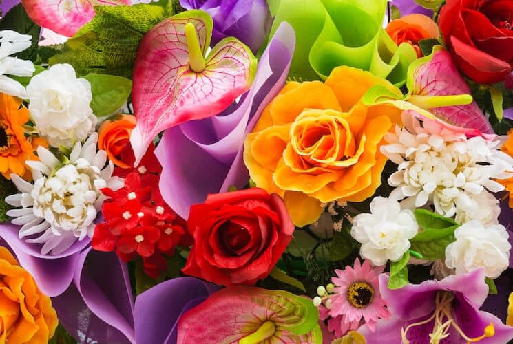 A vibrant assortment of colorful artificial flowers in various shapes and sizes.