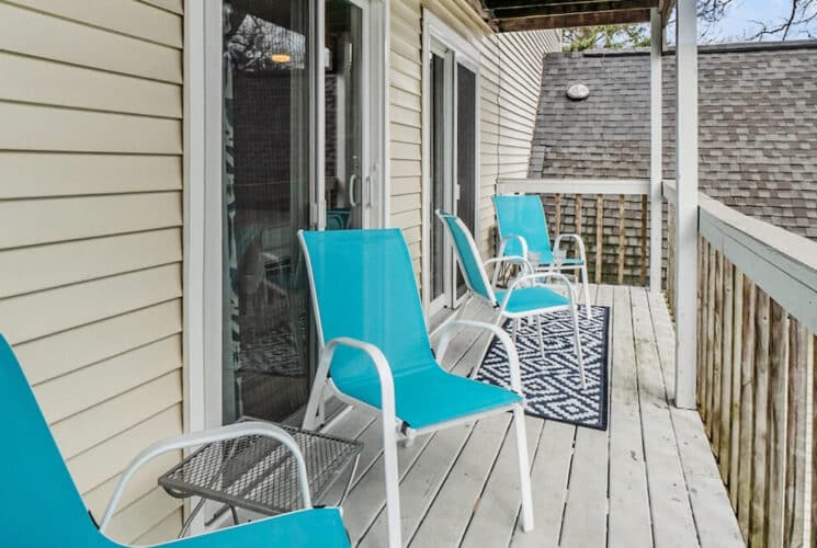 A private deck with blue outdoor chairs.