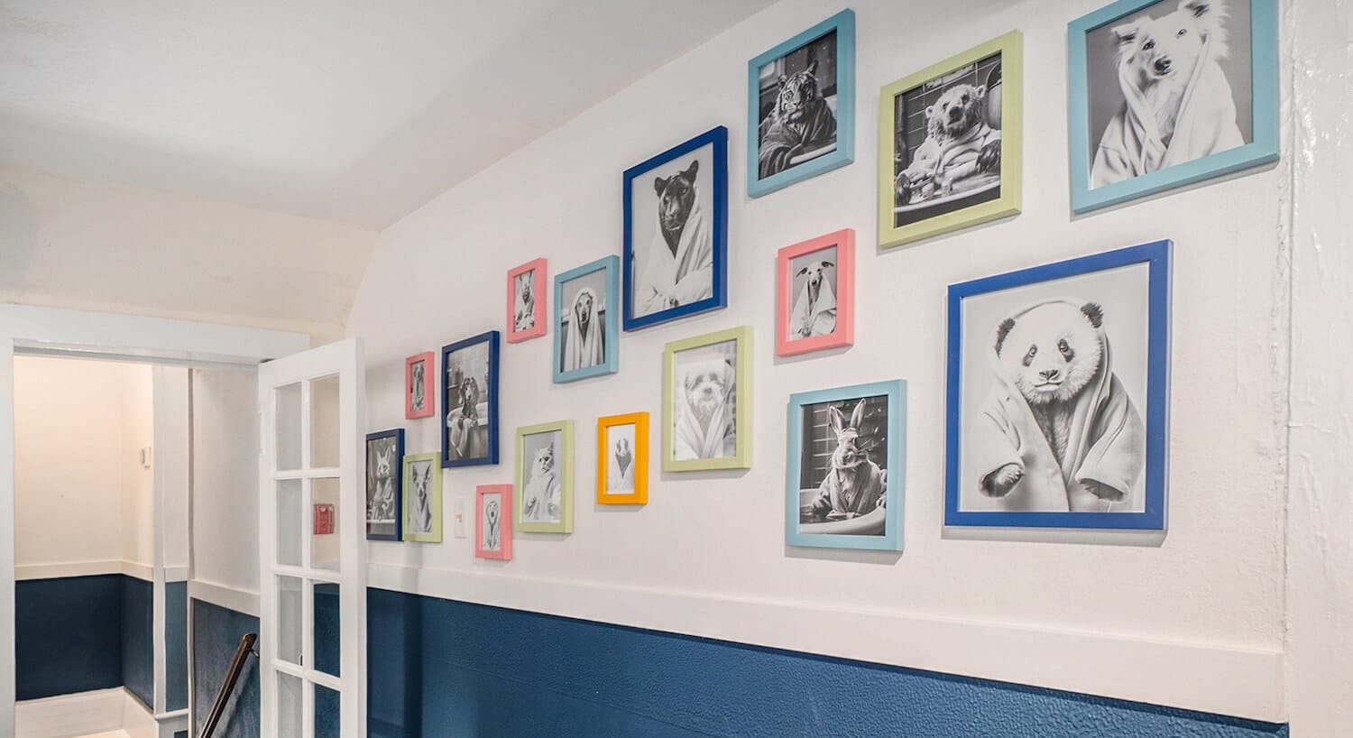 A hallway with dark blue and white walls, and several pictures of animal drawings on the wall.