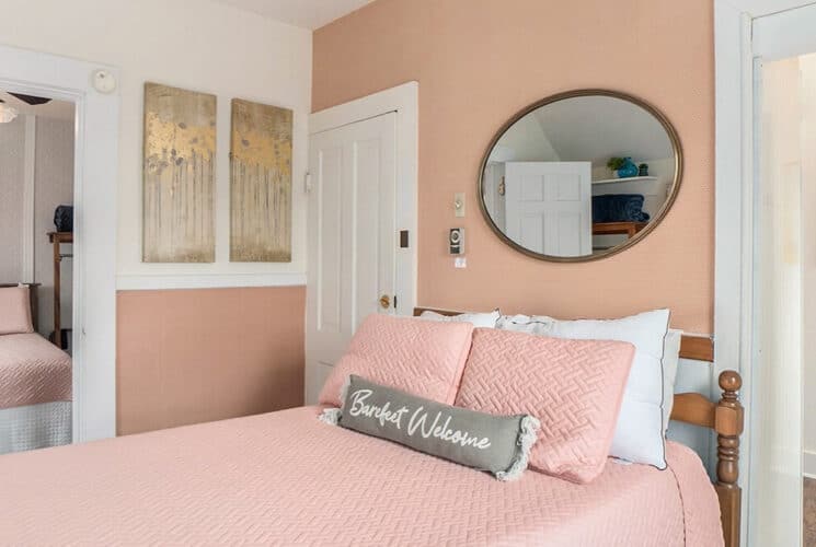 Adjoining bedrooms with pink and white walls, and beds with pink beddings.