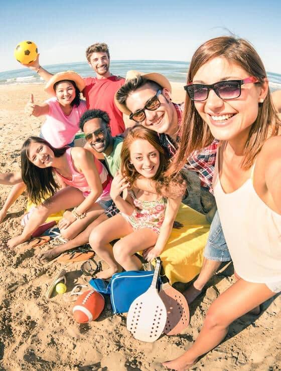 Group of smiling friends having fun on the beach