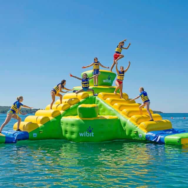 A group of people at play on a floating wibit aqua center.